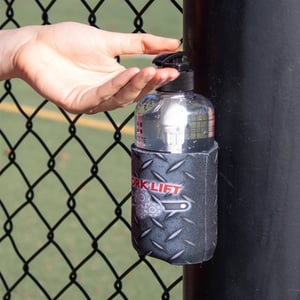 magnetic can cooler holding hand sanitizer while attached to fence